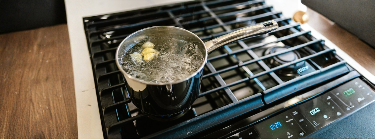A pot of water at a rolling boil with steam rising