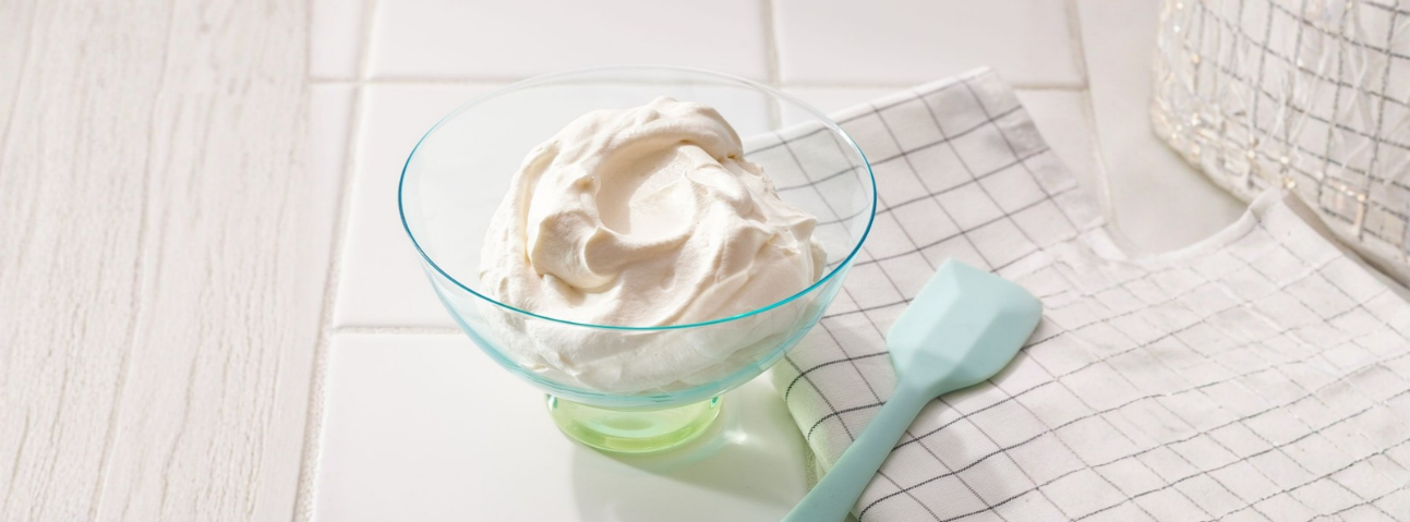 Bowl of whipped cream, spatula nearby