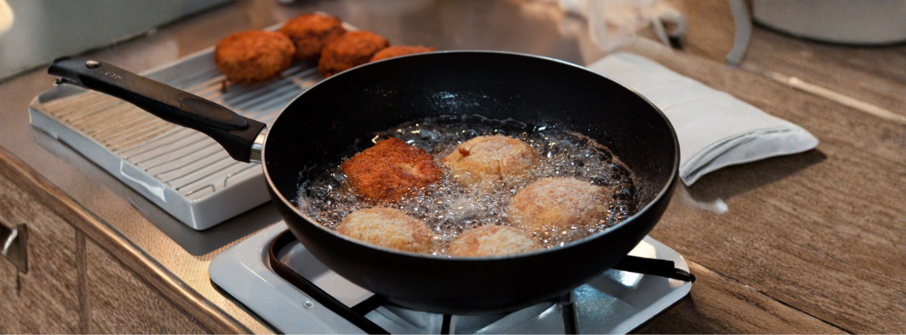 Chicken cutlet pan-frying in a skillet with golden-brown crust forming