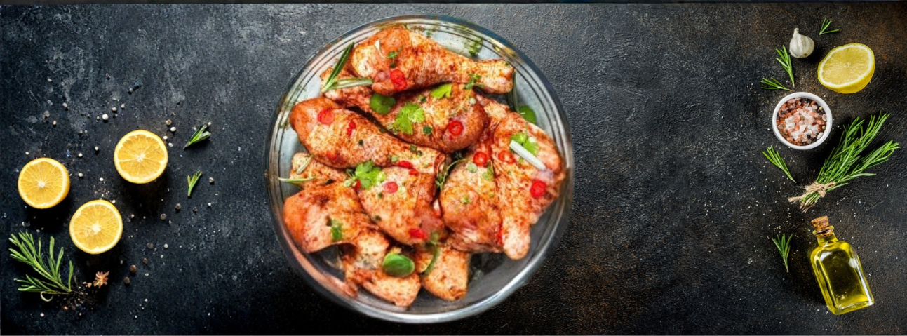 Chicken pieces marinating in a bowl with herbs, garlic, and citrus