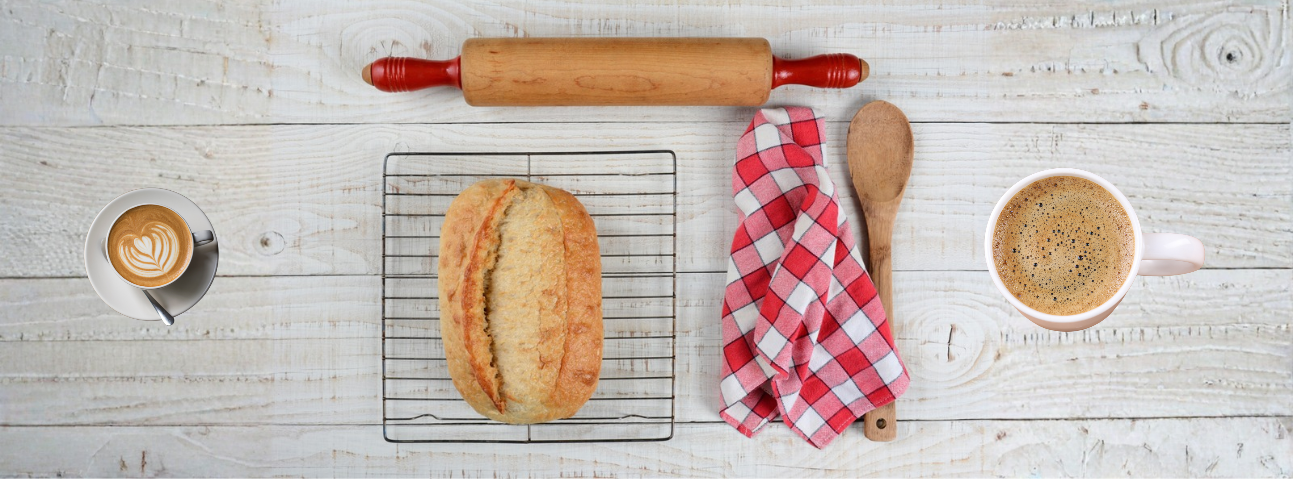 Golden bread on a wire cooling rack with cup of coffee nearby