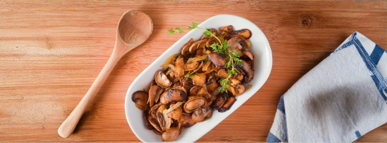 Sautéed mushrooms with a wooden spoon