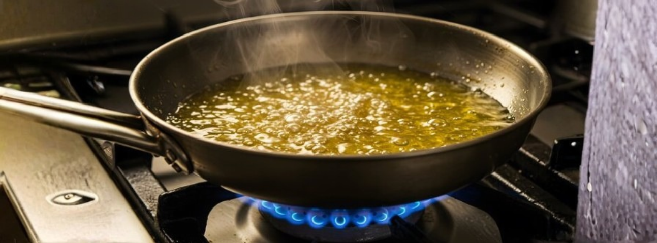 Shallow layer of oil shimmering in a stainless steel pan ready for pan-frying