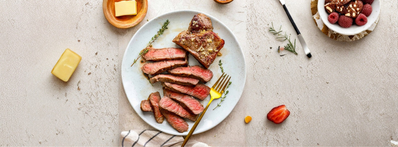 Sliced sous vide steak with even pink interior and a golden-brown seared crust.